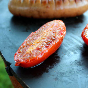 Teppanyaki style Ringgrill BBQ Grill cooking sausage and tomatoes