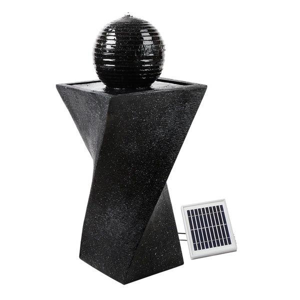 A black, twisted design solar-powered water fountain featuring a spherical solar panel on top and a ground holder. The fountain is made of polyresin with a weathered stone finish, set on a white background.