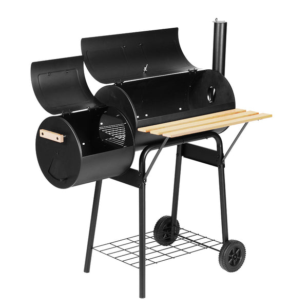 A black Grillz 2-in-1 offset charcoal smoker with a chrome-coated steel BBQ grill on top and a side firebox. It has a large front shelf, two wheels for mobility, and is set against a white background.