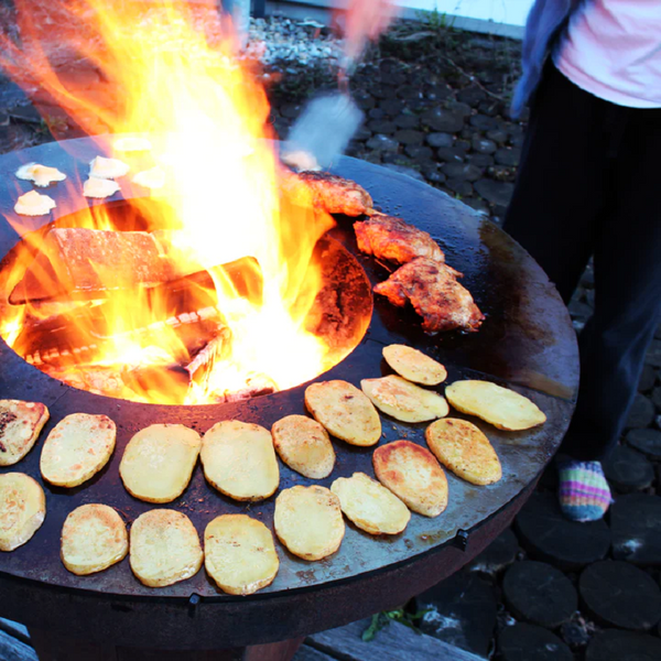 Cooking potato, eggs and chicken on a Teppanyaki style Ringgrill BBQ Grill, flames are coming up the centre of the BBQ.