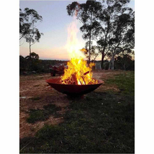 Load image into Gallery viewer,  The Cauldron Fire Pit 1500mm with fire burning in rural setting