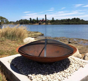 The Cauldron Cast Iron Fire Pit with a mesh cover
