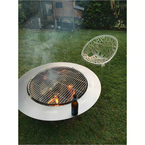 Teppanyaki Stainless Steel Fire Pit in backyard setting with fire burning