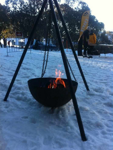 The Tripod Fire Pit in the snow with a burning fire
