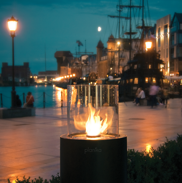 Totem Commerce Ethanol Burner out front of Poland Hilton hotel, in front of a body of water with people, boats and buildings in the background.