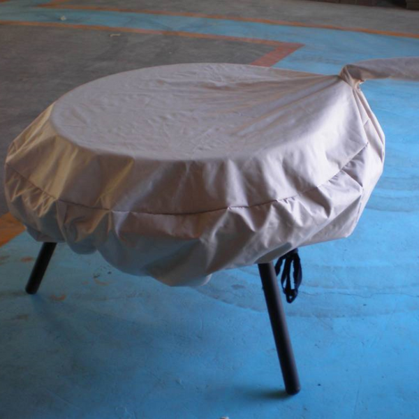 Waterproof Vinyl Fire Pit Cover on an Ultimate BBQ Fire Pit, sitting on a cement floor.