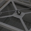 Close-up image of the top of the mesh screen lid of a metal fire pit with poker laying across the top of it.