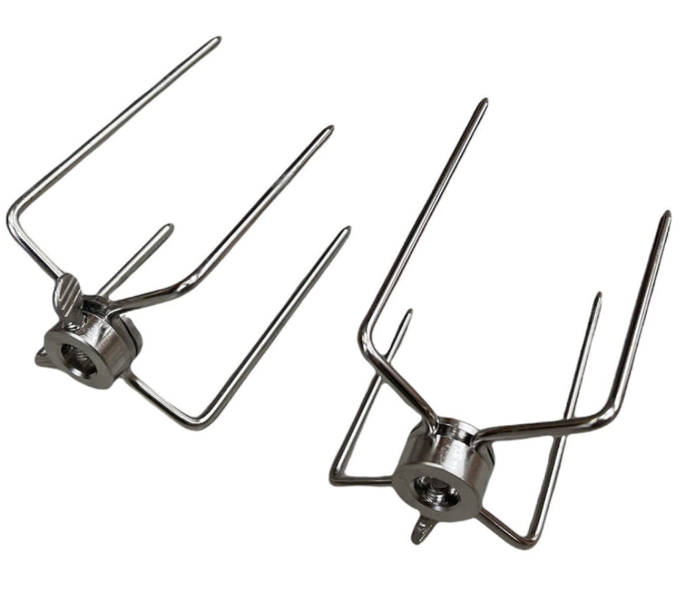Two stainless steel rotisserie spit fork stands on a white background