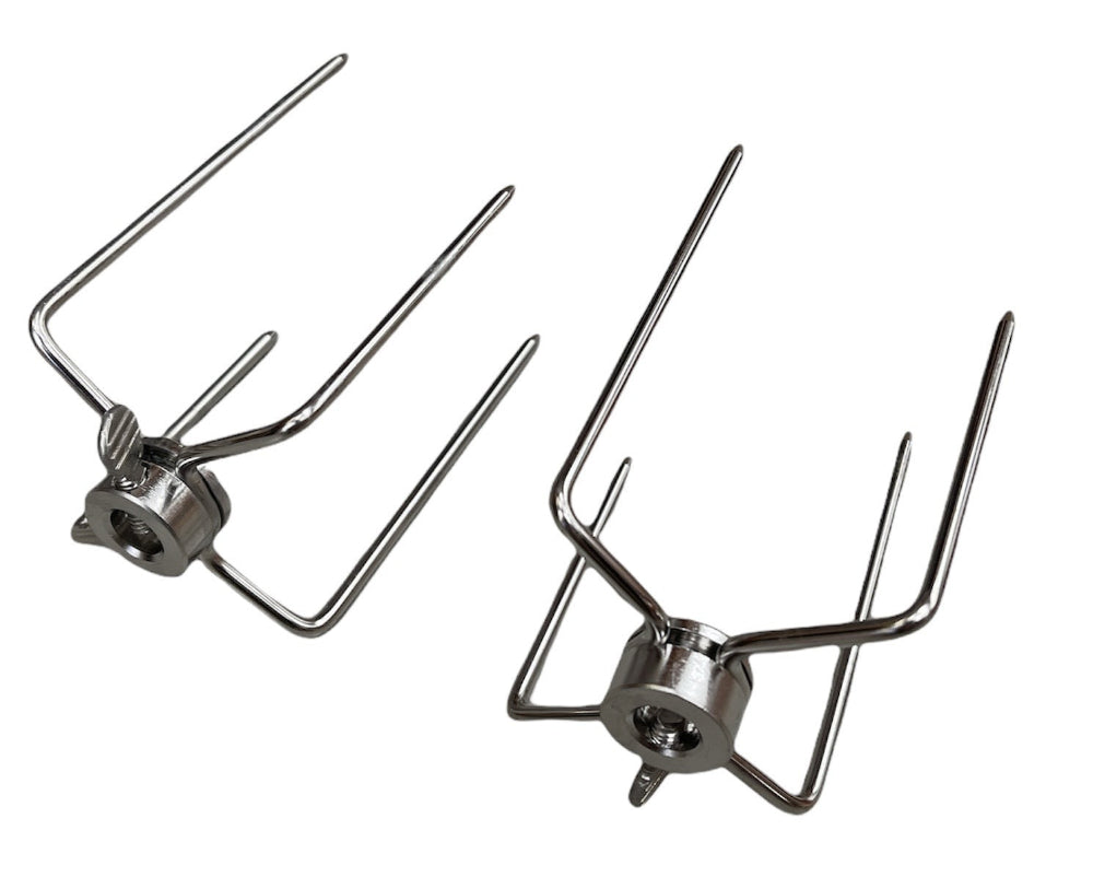 Two rotisserie spit forks on a white background