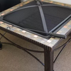 Black fire pit screen on a mosaic-tiled table