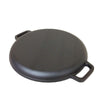 Black round pan upside down with handles on a white background
