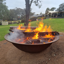 Load image into Gallery viewer, The Crucible Fire Pit with fire burning in a large backyard - Hot Fire Pits Australia