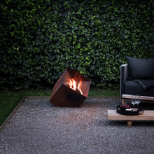 Load image into Gallery viewer, Firecube Fire Pit by Eva Solo with fire burning in an outdoor setting 