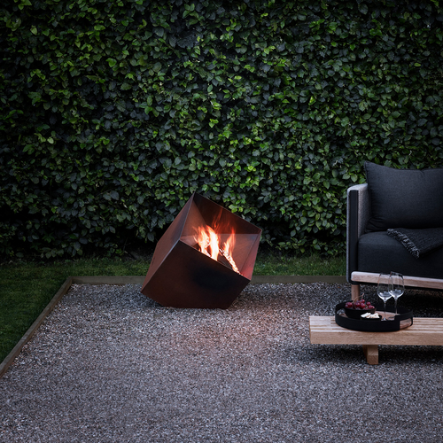 Firecube Fire Pit by Eva Solo with fire burning in an outdoor setting 