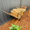 Metal firewood stack on a branded firewood rack against a metal fencing.