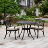 Outdoor patio set with black metal table and chairs on a stone patio.