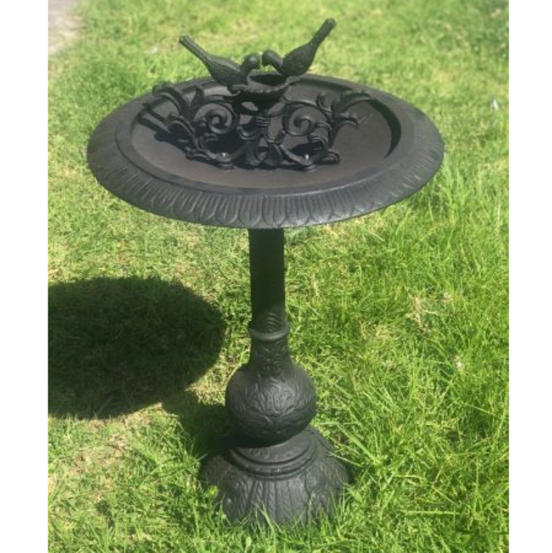 Two Birds Cast Iron Bird Bath in Black on a green grassy area.
