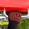 Black glove with red text holding onto a red barbecue grill handle.