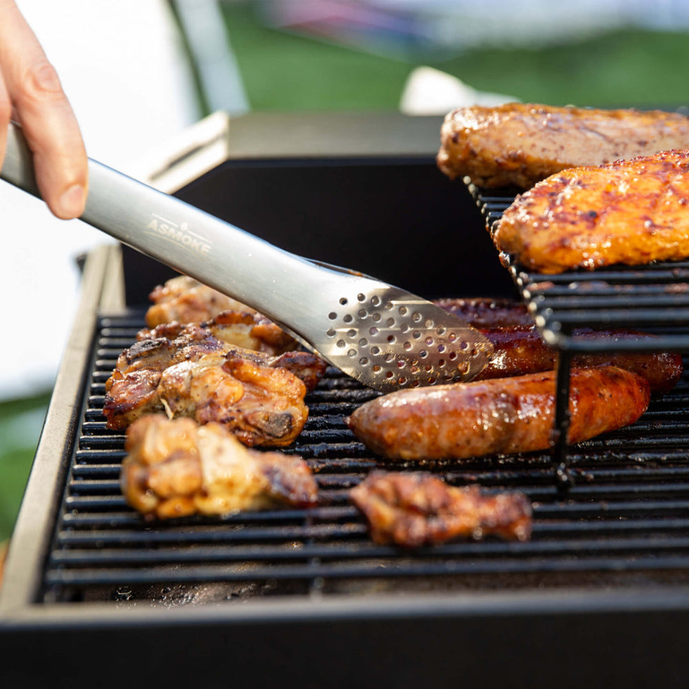 Grilling sausages with tongs on a barbecue grill