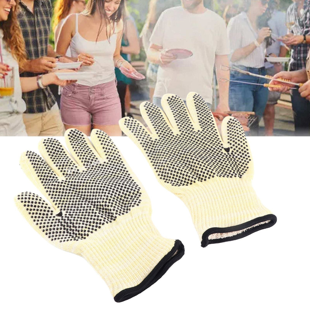 Pair of beige gloves with black dots on a white background, people in the background.