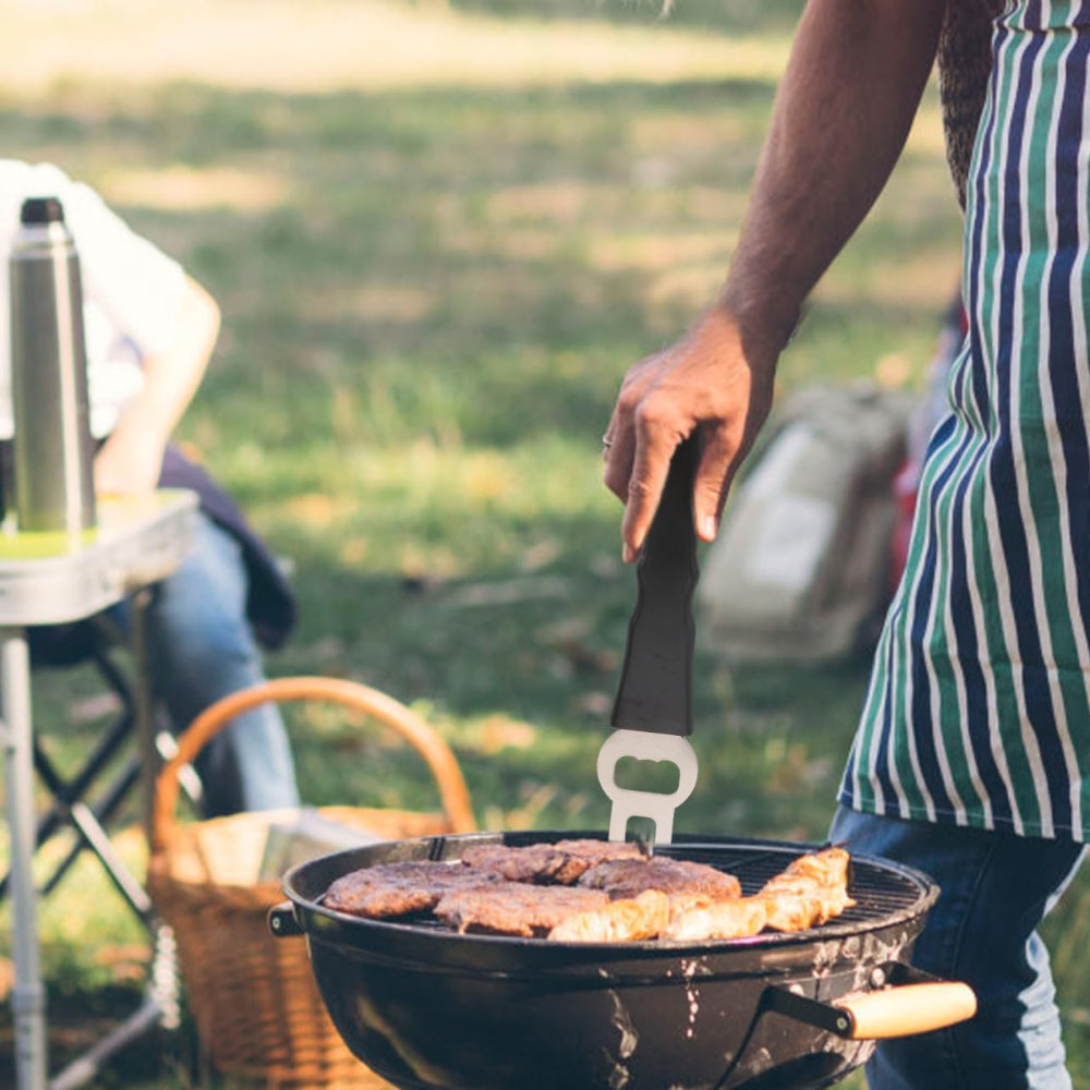 Person grilling food outdoors with a blurred background