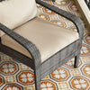 Wicker chair with beige cushions on a patterned floor