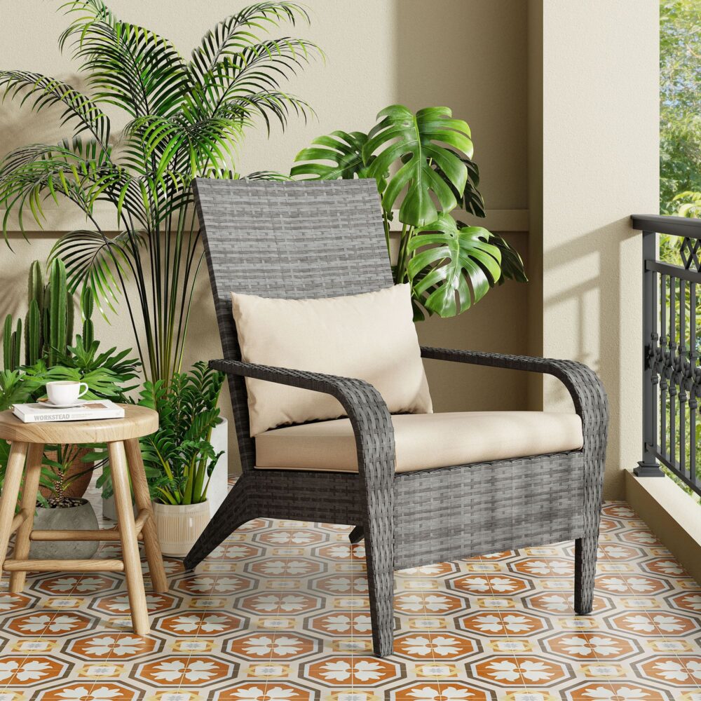 Gray wicker chair with beige cushion on a balcony with plants and a small table.
