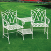 A set of two white wrought iron outdoor chairs with a matching center table on a green artificial grass surface.