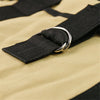 Close-up of a black canvas strap with a silver metal D-ring buckle on a beige fabric surface.