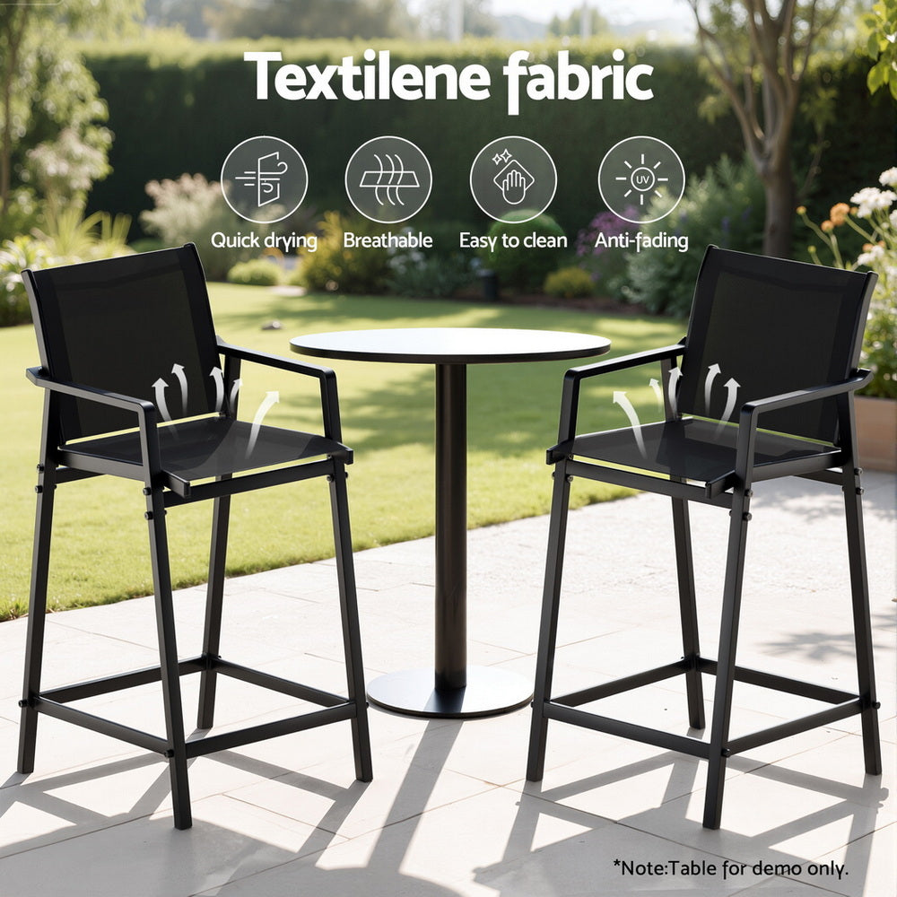 Outdoor furniture set with two high chairs and a round table on a patio, featuring Textilene fabric.