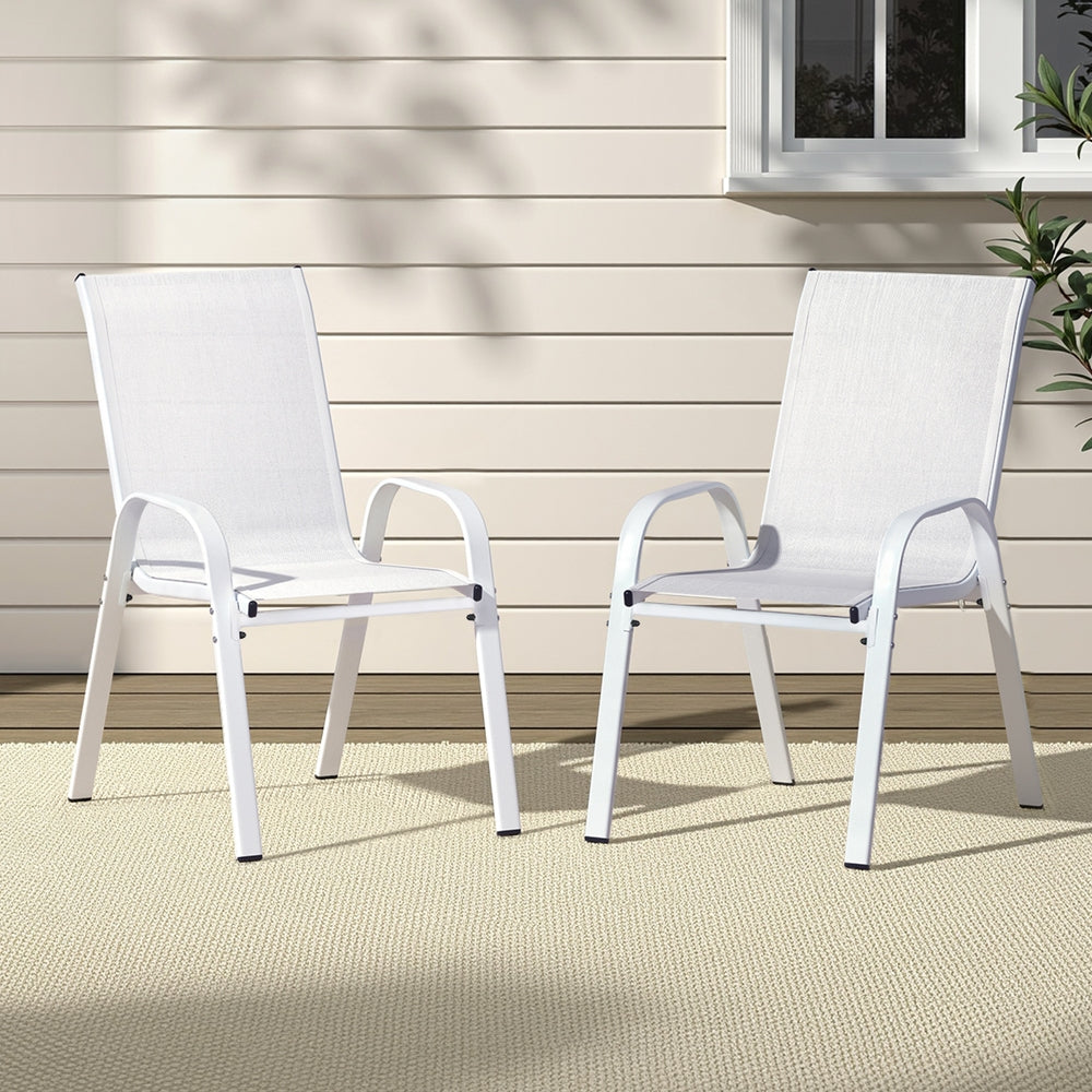 Two white chairs on a patio with a neutral background