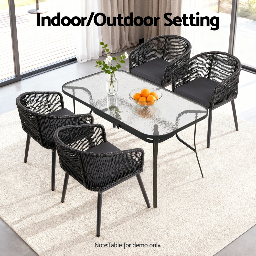 Black outdoor furniture set with a glass table on a patio.