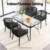 Black outdoor furniture set with a glass table on a patio.
