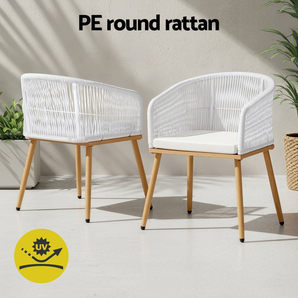 Two white rattan chairs with wooden legs on a light background