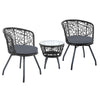 A three-piece outdoor bistro set comprising two high-backed chairs with black cushions and a round rattan table with a clear glass top on a black frame, set against a white background.