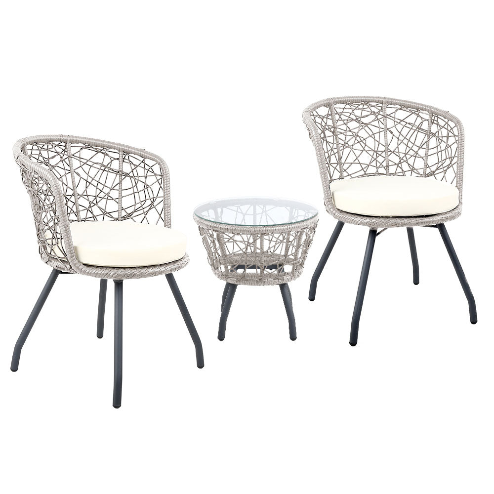 A three-piece outdoor bistro set comprising two high-backed chairs with beige cushions and a round rattan table with a clear glass top on a grey frame, set against a white background.