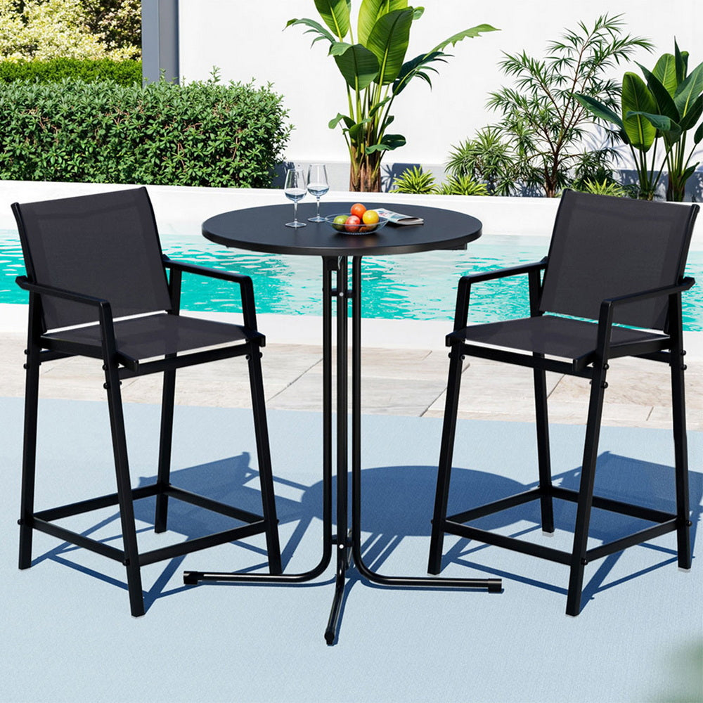 Black outdoor bar set with two stools and a table by a pool