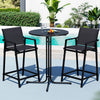 Black outdoor bar set with two stools and a table by a pool