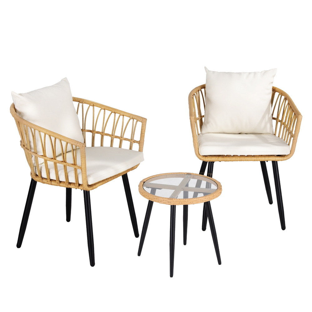 Two wicker chairs with white cushions and a matching table on a white background