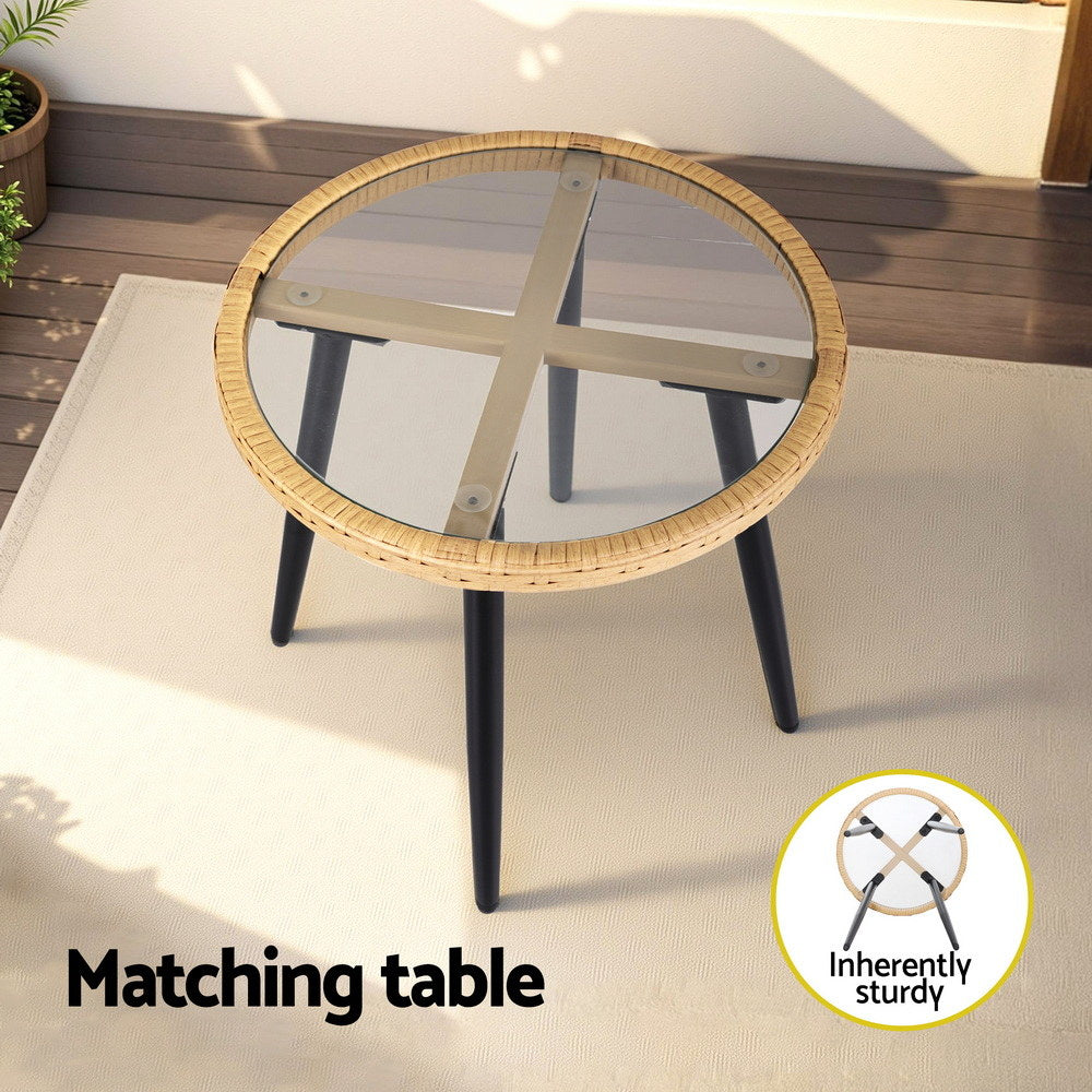 Round table with wicker top and black legs on a wooden deck