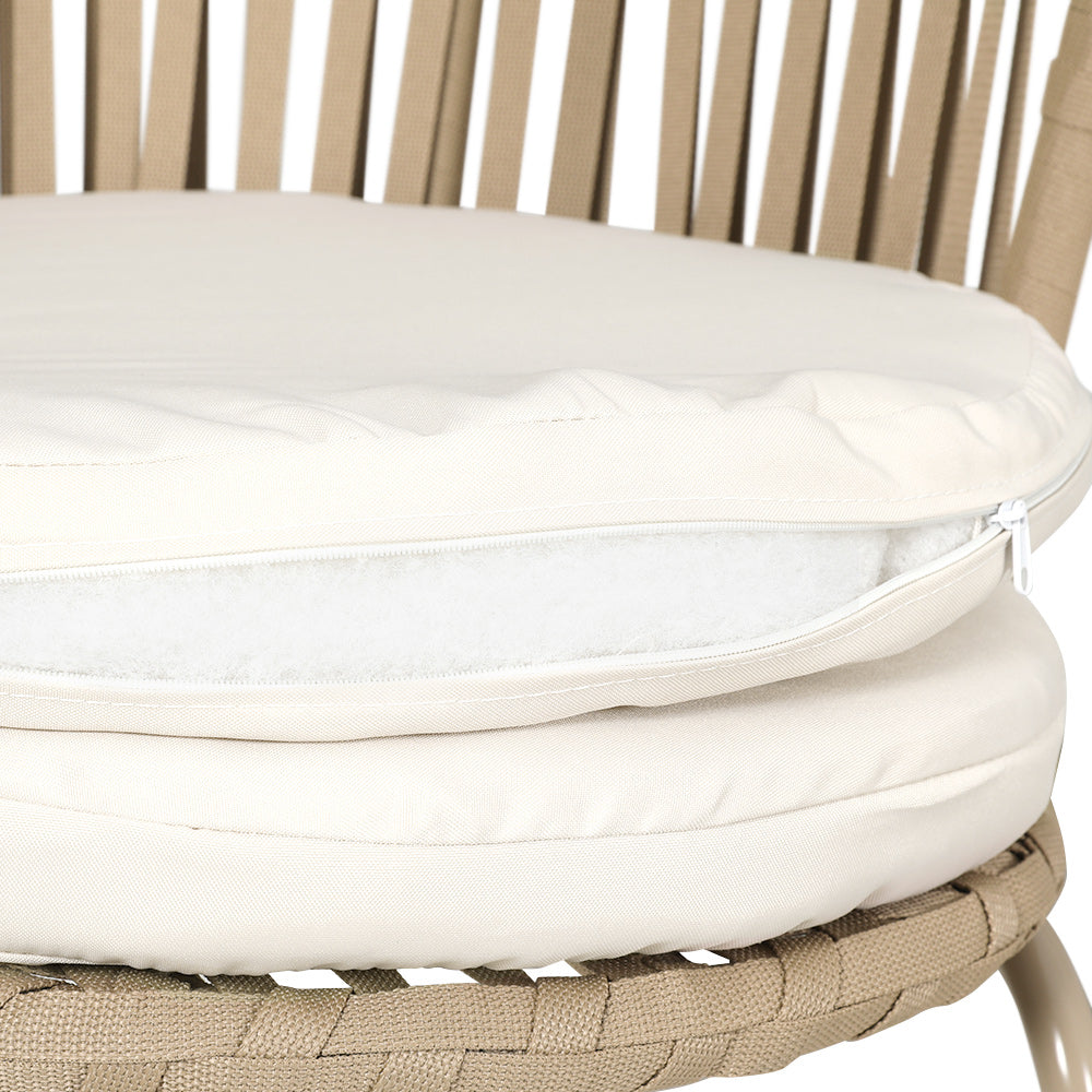 Close up view of the seat of a beige chair with rope weaving and two cream cushions, one with zip open showing the stuffing inside it, on a white background.