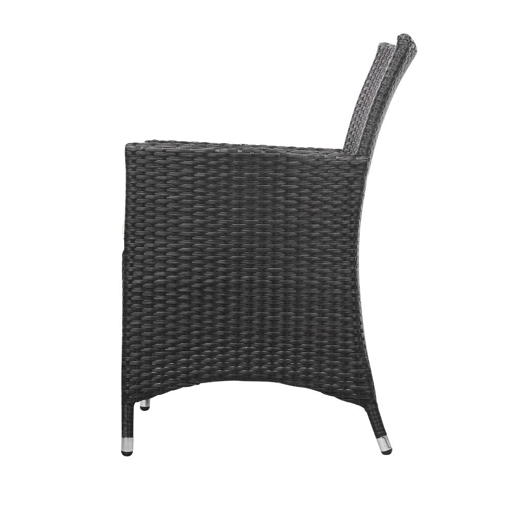 Side on view of a black wicker chair set with a white background. 