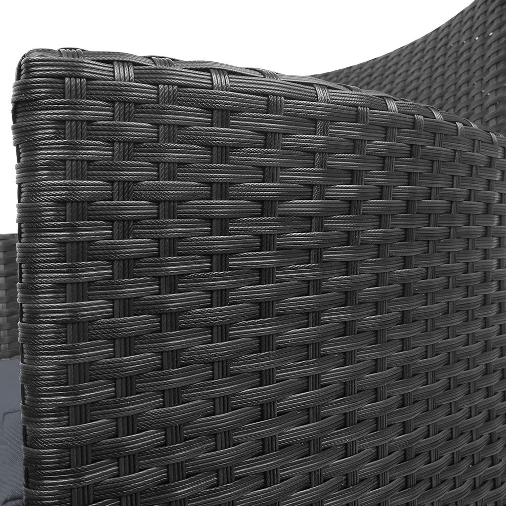 Close-up view of a black wicker chair showing the detailed weaving with a white background. 