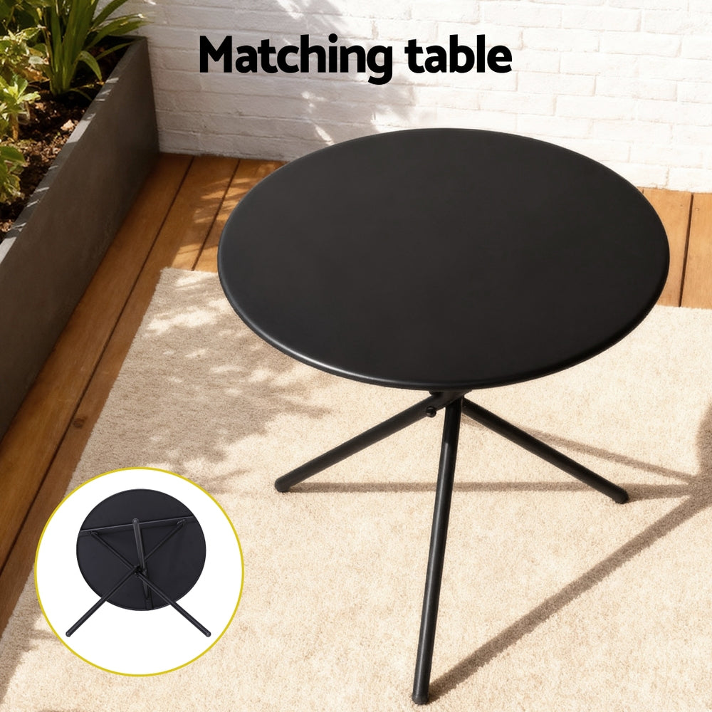 Black round table with three legs on a wooden deck