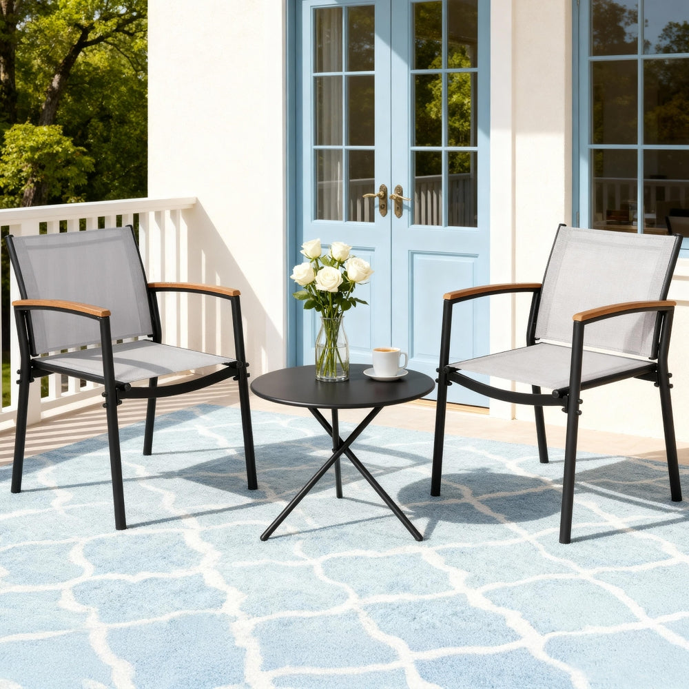 Outdoor patio set with two chairs and a small table on a patterned patio floor.