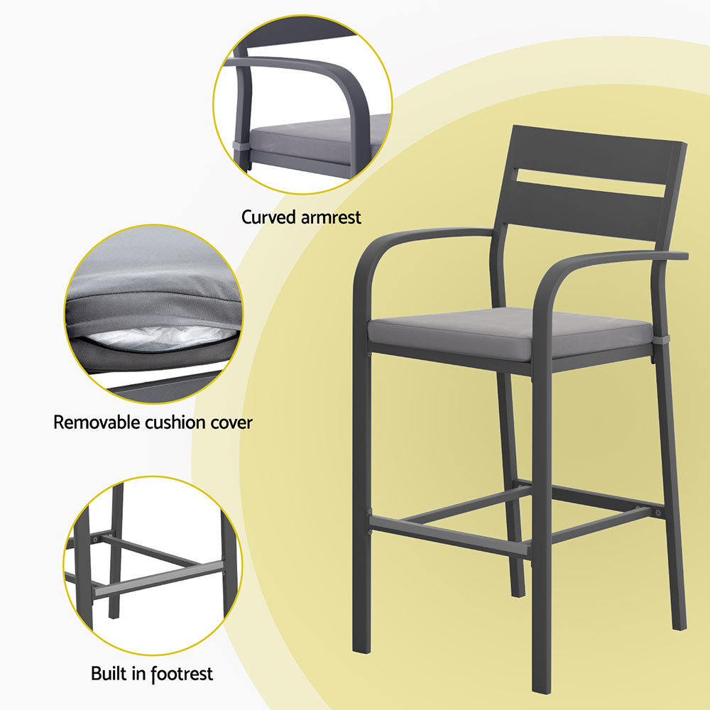 Black bar stool with gray cushion on a yellow background, highlighting features like curved armrest and built-in footrest.
