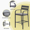 Black bar stool with gray cushion on a yellow background, highlighting features like curved armrest and built-in footrest.