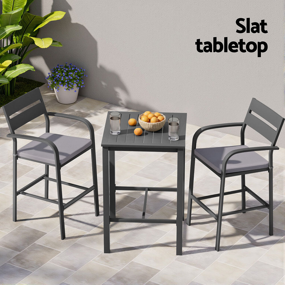 Outdoor patio set with two chairs and a table on a tiled patio, featuring a slat tabletop.