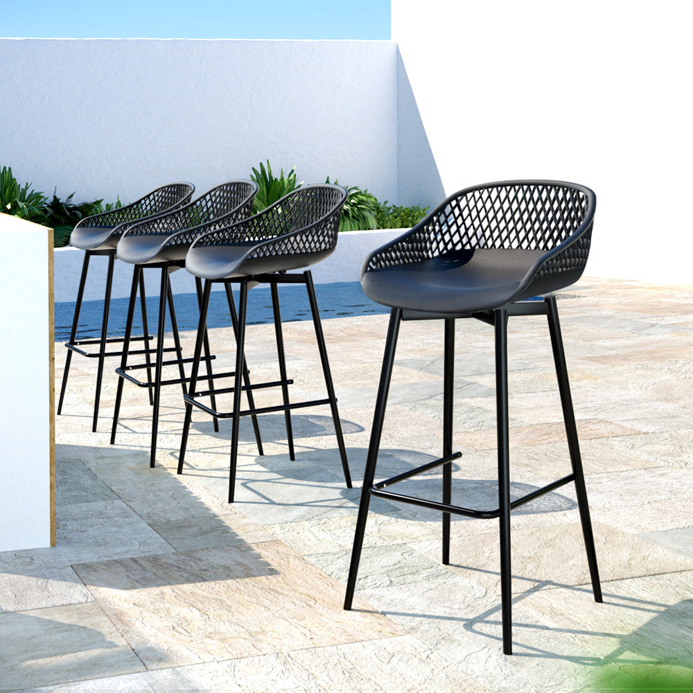 A set of four black Gardeon outdoor bar stools with plastic seats and metal frames, set in a row on a tiled surface in an outdoor poolside setting.