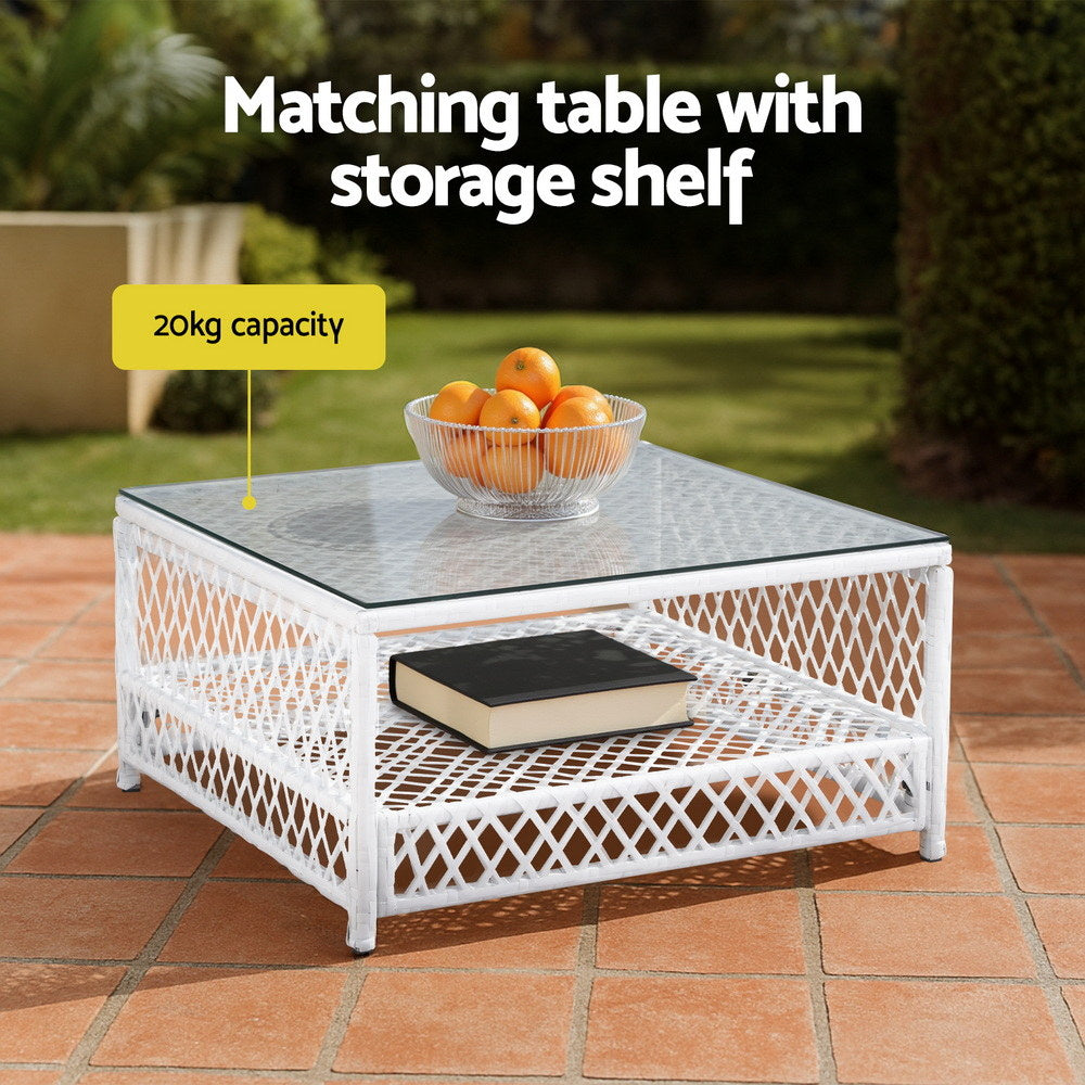 White matching table with storage shelf on a patio, featuring a bowl of oranges and a book.